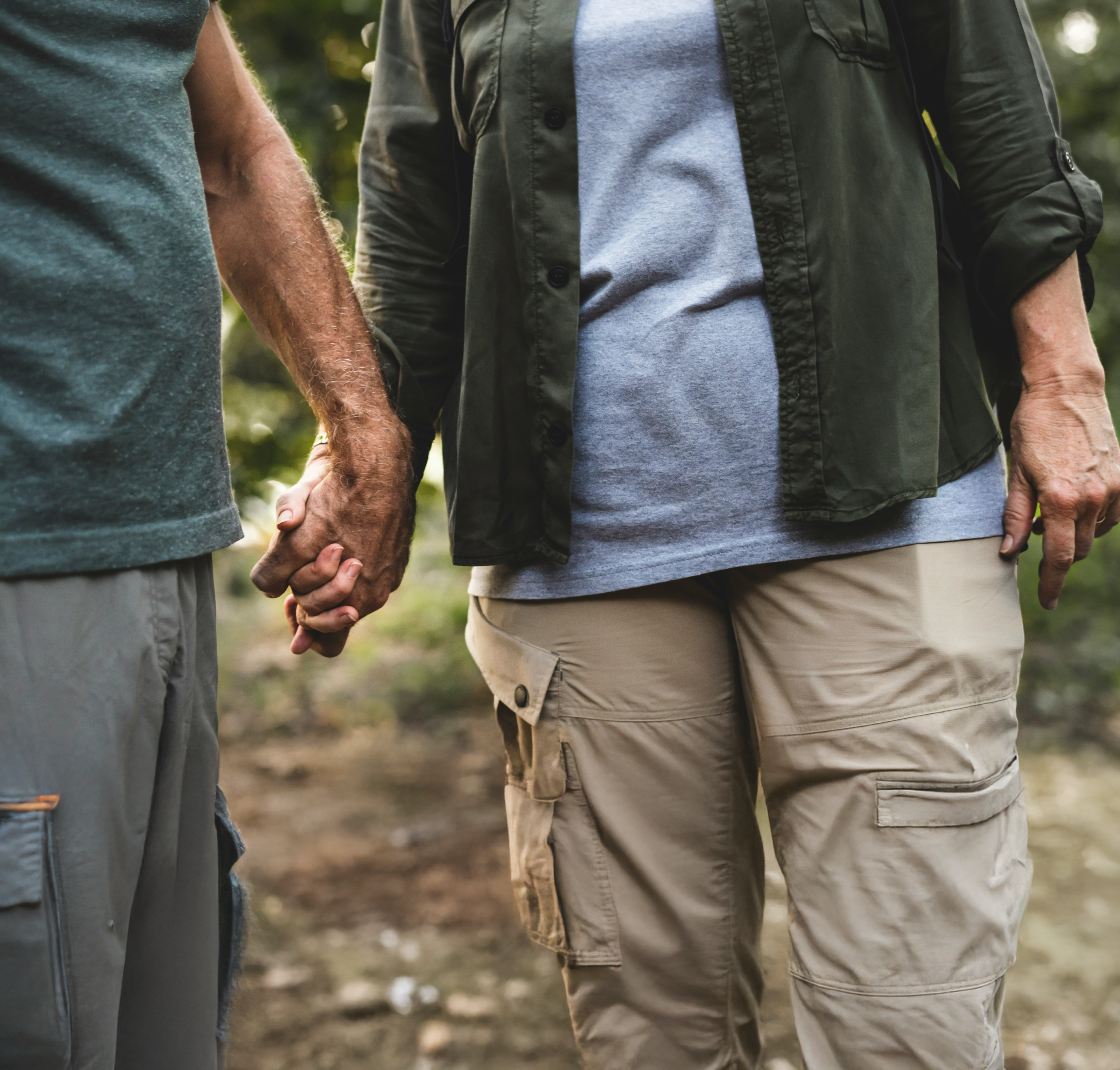 two people holding hands wearing green outfits